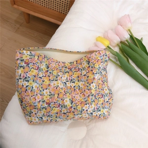 Detail of floral canvas storage bag with zipper on white quilted fabric background
