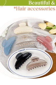 Close-up of semi-circle hair claws in six glossy colors on a decorative wooden table