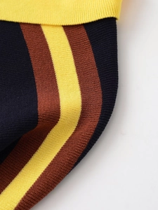 Close-up of the knitted texture with yellow, dark blue and brown stripes on the polo shirt