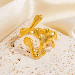 Macro shot of gold abstract liquid metal ring on a porous stone with silk background