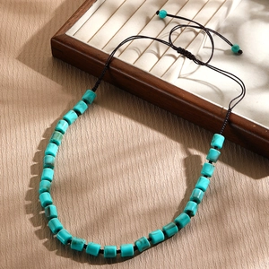 Macro view of handmade turquoise beaded necklace with adjustable brown braided cord details