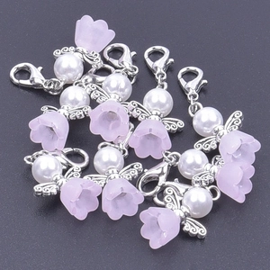 Macro shot of silver angel wing charms with pink flower beads and lobster clasps