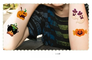 Detail of cute Halloween temporary tattoos with pumpkin and ghost designs on a child's arm