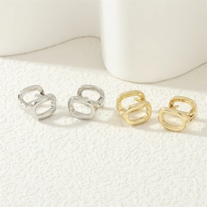 Detailed view of 18K gold and silver plated horseshoe buckle earrings on a white surface