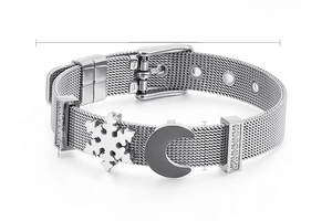 Dettaglio del bracciale a maglia argentata regolabile con ciondoli a luna, fiocco e pietre zirconi