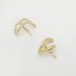 Detail showing the abstract wavy design and glossy gold finish of the alloy hair clip