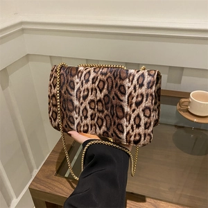 Elegante borsa a tracolla leopardata con catena dorata in un ambiente accogliente
