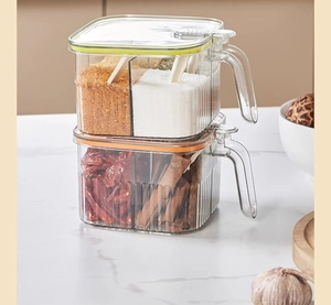 Detail of stackable clear seasoning boxes with airtight lids, spoons and colorful handles