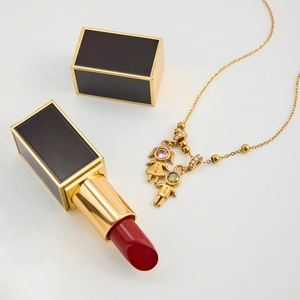 Detailed close-up of 18K gold-plated necklace with pink and green boy-girl figure pendants