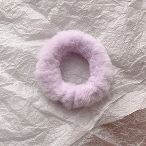 Macro shot of soft lavender faux rabbit fur scrunchie with elastic hair band texture