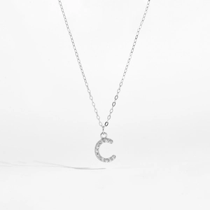 Macro shot of silver S925 letter C pendant with shimmering cubic zirconia pavé setting