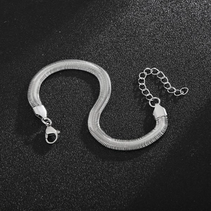 Detailed view of silver flat snake chain bracelet with lobster clasp on black background