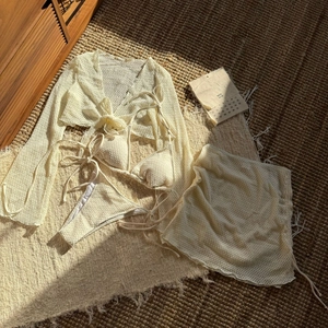 Dettaglio del set da bagno quattro pezzi all'uncinetto crema con cardigan e tessuto materico