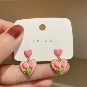 Dettaglio dell'orecchino a cuore rosa con ciondolo a tulipano e bordo dorato a mano