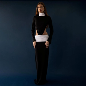 Detail of waist cutout with white pleated fabric on a slim black long sleeve dress