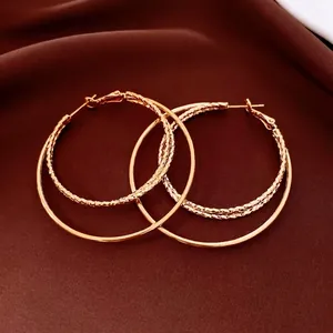 Boucles d'oreilles doubles créoles dorées 18 carats avec détails ciselés sur soie
