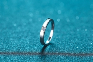 Macro detail of a 925 silver ring featuring a square-cut moissanite stone on blue backdrop