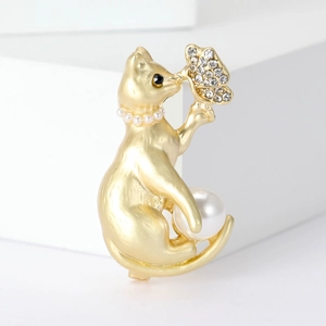 Cute golden cat brooch with pearl necklace and diamond butterfly on white background