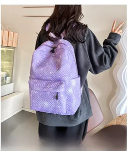 Detalle de mochila violeta acolchada con patrones de corazón y bolsillos laterales