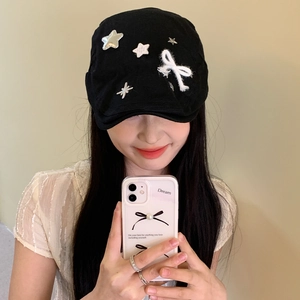 Retro black newsboy hat with silver star studs and a white bow accent for women