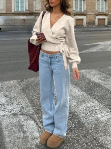 Elegant beige V-neck wrap knit top styled with light blue jeans and camel boots