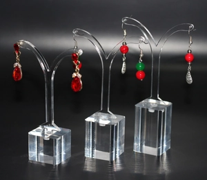 Three transparent acrylic earring display stands in varying heights with square bases