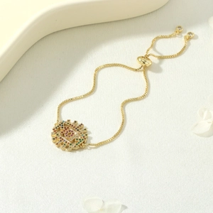 Detail of gold evil eye bracelet with colorful zircons and adjustable slider clasp
