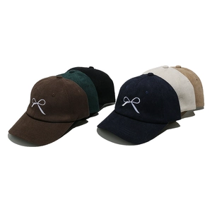 Detail showing various colors of corduroy baseball caps with white bow embroidery
