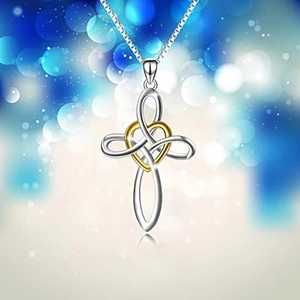 Detail view of silver heart pendant with Celtic knot cross design on a simple chain