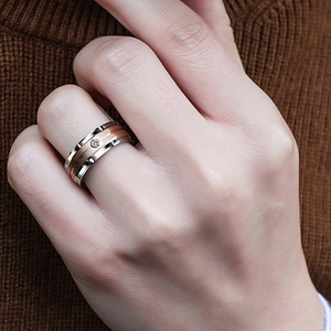 Close-up of a two-tone silver and rose gold ring with a small diamond on a hand