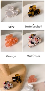 Close-up of four acetic acid hair claws in marble, tortoiseshell, orange, and mixed colors