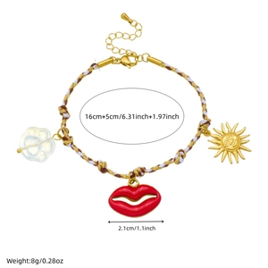 Bohemian braided rope bracelet with red lips and gold sun charms on white background