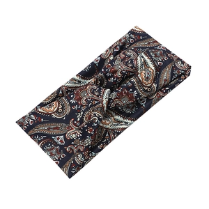 Detail of dark blue paisley yoga headband with knot design and soft fabric texture
