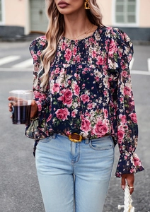 Detail of smocked neck and pink floral print on a dark blue long sleeve chiffon blouse