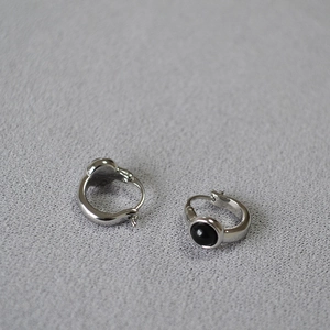 Detailed close-up of vintage silver brass earrings with inlaid black agate gemstones