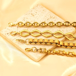 Detail of four golden hip-hop bracelets with various chain links on white stone