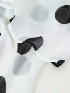 Makro-Detail von atmungsaktivem weißem Chiffonstoff mit klassischen schwarzen Punkten