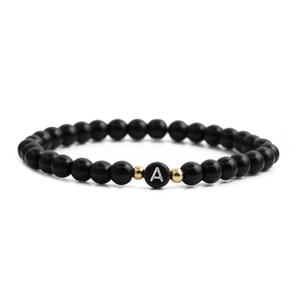 Minimalist black matte stone beaded bracelet with gold accents and heart letter A charm