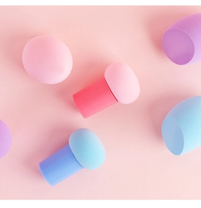 Detailed close-up of mushroom-head puffs and droplet makeup sponges in pastel colors