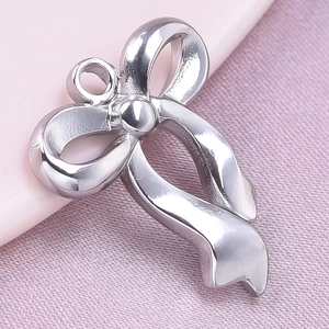 Macro shot of silver bow pendant made of polished 304 stainless steel on pink fabric