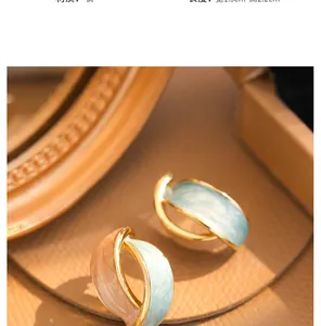 Detailed macro view of retro French enamel clip earrings showing size and metal texture