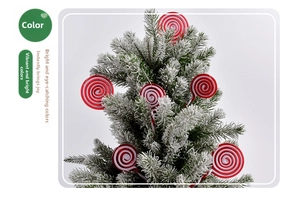 Close-up of red and white spiral candy ornaments hanging on a snowy Christmas tree branch