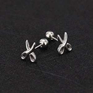 Close-up of silver scissors-shaped studs with secure screw-back ball closure