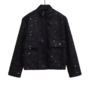 Close-up of black sequined tweed jacket with stand collar and front pockets detail