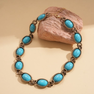 Macro shot of oval turquoise stone pendant with bronze rope texture frame and chain