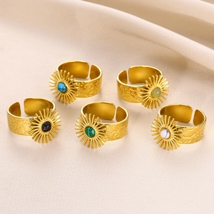 Detail of adjustable sunflower rings with assorted colorful gemstones on beige fabric