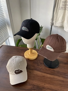 Detailed embroidery and distressed patch on vintage baseball caps in black and beige