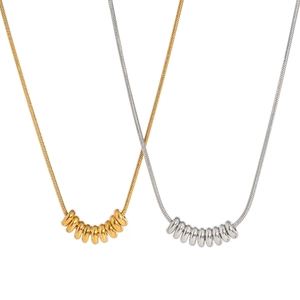 Elegant gold and silver snake chain necklaces with beaded ring pendants on white background