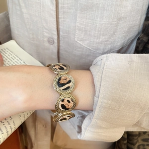 Detailed close-up of leopard print textures and vintage gold rings on a stylish bracelet