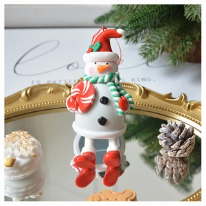 Festive 3D snowman ornament placed on a gold mirror tray with pine cones and needles